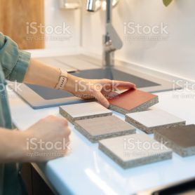 woman choosing kitchen countertop material texture from samples